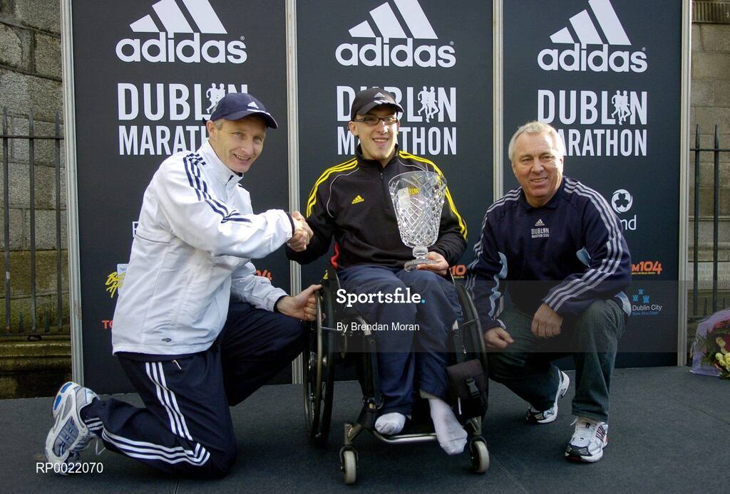 31 October 2005; Men's Wheelchair race winner John Glynn is presented with his trophy by Race Director Jim Aughney, left, and Robin Money, Head of Sports Marketing, adidas Area North, during the 2005 adidas Dublin City Marathon. Picture credit: Brendan Moran / SPORTSFILE