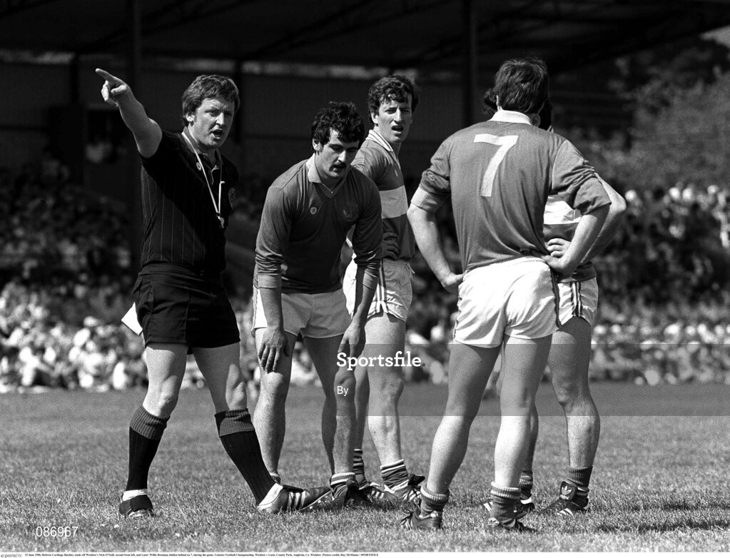 15 June 1986; Referee Carthage Buckley sends off Wicklow's Nick O'Neill, second from left, and Laois' Willie Brennan, hidden behind no 7, during the game. Leinster Football Championship, Wicklow v Laois, County Park, Aughrim, Co. Wicklow. Picture credit; Ray McManus / SPORTSFILE