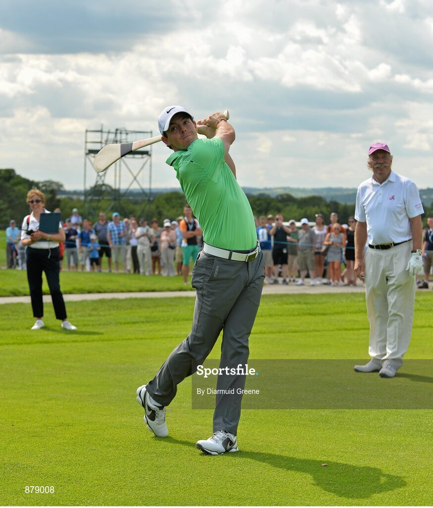 18 June 2014; Rory McIlroy, watched by playing partner Dermot Desmond, after hitting a golf ball with a hurley on the 9th fairway during the 2014 Irish Open Golf Championship Pro-Am. Fota Island, Cork. Picture credit: Diarmuid Greene / SPORTSFILE