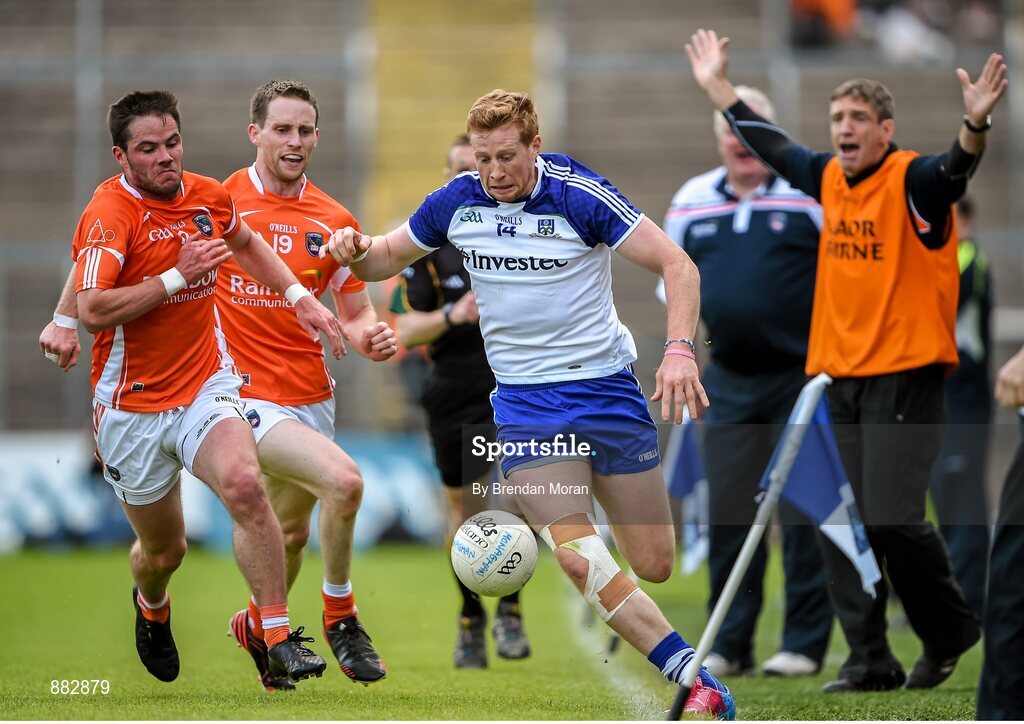 28 June 2014; Kieran Hughes, Monaghan, keeps the ball in play as he is pursued by Eugene McVerry and Finnian Moriarty, Armagh, as Armagh assistant manager Kieran McGeeney appeals for a sideline ball. Ulster GAA Football Senior Championship, Semi-Final, Armagh v Monaghan, St Tiernach's Park, Clones, Co. Monaghan. Picture credit: Brendan Moran / SPORTSFILE