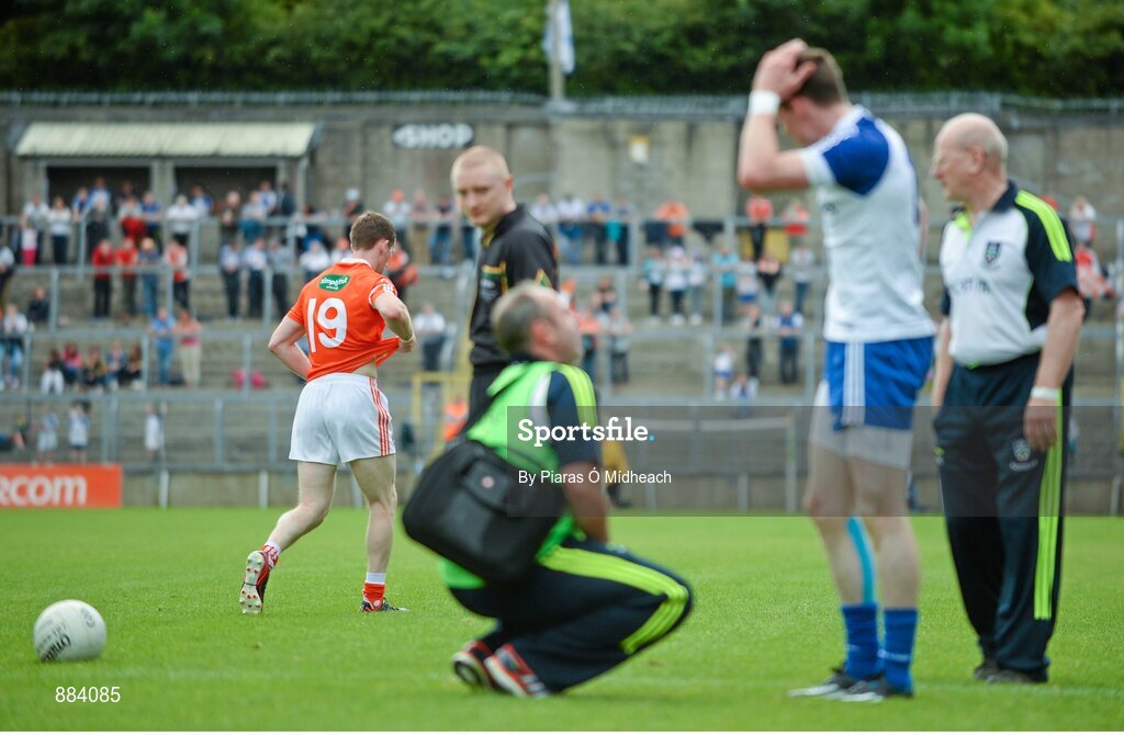 6 July 2014; Finnian Moriarty, left, Armagh, leaves the field after picking up a black card for a foul on Conor McManus, Monaghan, receiving treatment in the foreground. Ulster GAA Football Senior Championship, Semi-Final Replay, Armagh v Monaghan, St Tiernach's Park, Clones, Co. Monaghan. Picture credit: Piaras Ó Mídheach / SPORTSFILE