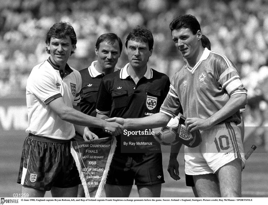 12 June 1988; Team captains Bryan Robson of England, left, and Frank Stapleton of Republic of Ireland shake hands and exchange pennants prior to the UEFA European Football Championship Finals Group B match between England and Republic of Ireland at Neckarstadion in Stuttgart, Germany. Photo by Ray McManus/Sportsfile