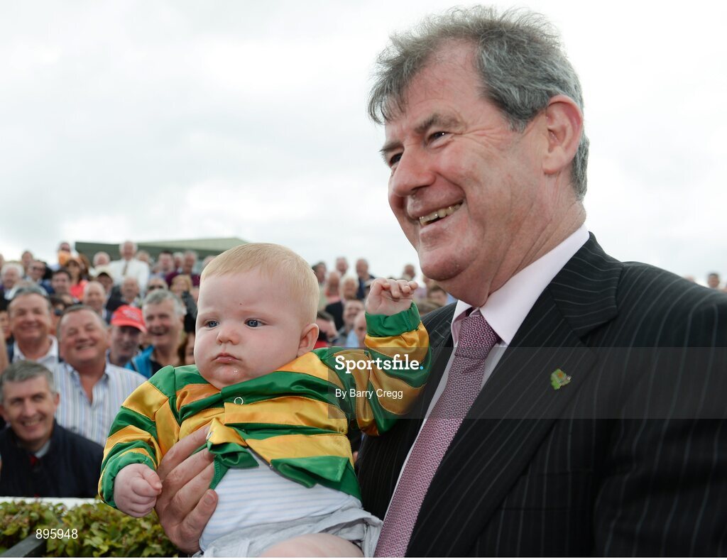 31 July 2014; JP McManus, owner of Thomas Edison, who won the Guinness Galway Hurdle Handicap with Tony McCoy poses for a photograph with young supporter Conor Jordan, aged 6 months, from Navan, Co. Meath. Galway Racing Festival, Ballybrit, Co. Galway. Picture credit: Barry Cregg / SPORTSFILE
