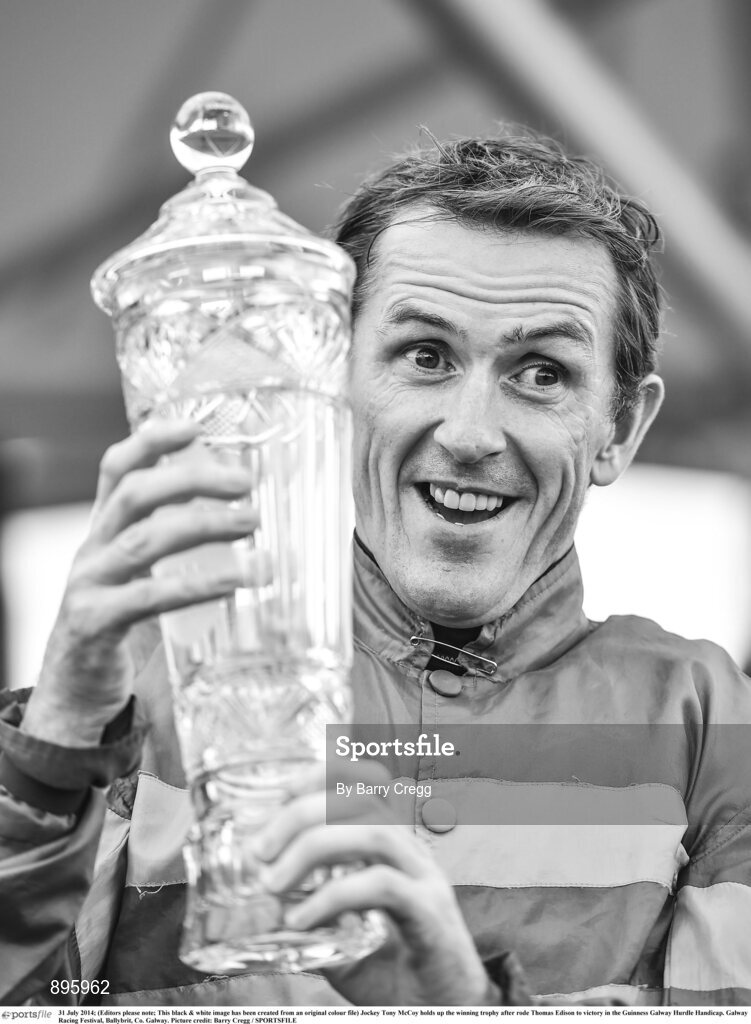 31 July 2014; (Editors please note; This black & white image has been created from an original colour file) Jockey Tony McCoy holds up the winning trophy after rode Thomas Edison to victory in the Guinness Galway Hurdle Handicap. Galway Racing Festival, Ballybrit, Co. Galway. Picture credit: Barry Cregg / SPORTSFILE