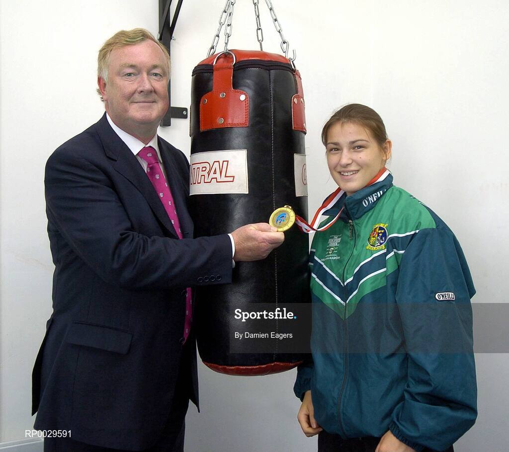 14 September 2006; John O'Donoghue, T.D., Minister for Arts, Sport and Tourism, admires Irish Boxer Katie Taylor's second Women's European Senior Championship goal medal at an announcement of the allocation of more than €2 million under the 'Women in Sport' initiative. This initiative has been developed to encourage girls and women into sport and supporting women's roles within sports organisations. Irishtown Athletic Stadium, Ringsend, Dublin. Picture credit: Damien Eagers / SPORTSFILE