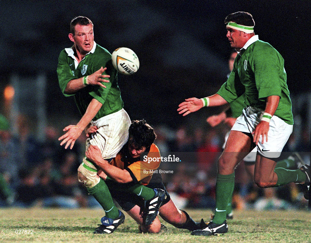 5 June 1999; David Corkery of Ireland gets the ball away to Dion O'Cuinneagain despite the tackle of Julian Moreton, New South Wales Country, during the Ireland Rugby tour to Australia match between New South Wales Country XV and Ireland at the Woy Woy Oval in New South Wales, Australia. Photo by Matt Browne/Sportsfile