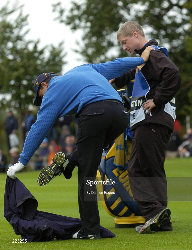 23 September 2006; Padraig Harrington, Team Europe 2006, is assisted by his caddy Ronan Flood as he takes off his rain gear during Saturday morning's four-ball matches. 36th Ryder Cup Matches, K Club, Straffan, Co. Kildare, Ireland. Picture credit: Damien Eagers / SPORTSFILE