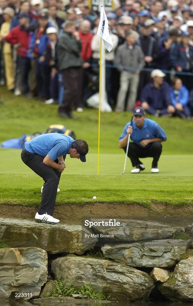 23 September 2006; Sergio Garcia, Team Europe 2006, studies the lie of his ball on the 11th green watched by partner Jose Maria Olazabal during Saturday morning's four-ball matches. 36th Ryder Cup Matches, K Club, Straffan, Co. Kildare, Ireland. Picture credit: Matt Browne / SPORTSFILE