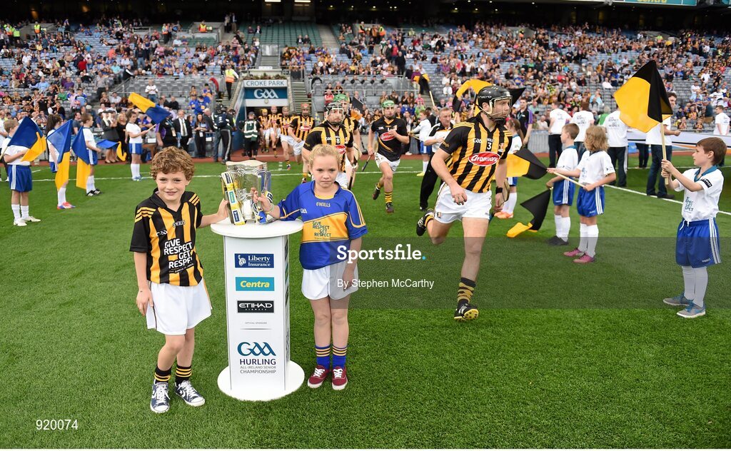 27 September 2014; Roísín O'Meara, Narnane NS, Tipperary, and Alex Cass, Thomastown NS, Kilkenny, carry the Liam MacCarthy cup onto the pitch ahead of the game as Kilkenny's JJ Delaney runs out. GAA Hurling All Ireland Senior Championship Final Replay, Kilkenny v Tipperary. Croke Park, Dublin. Picture credit: Stephen McCarthy / SPORTSFILE
