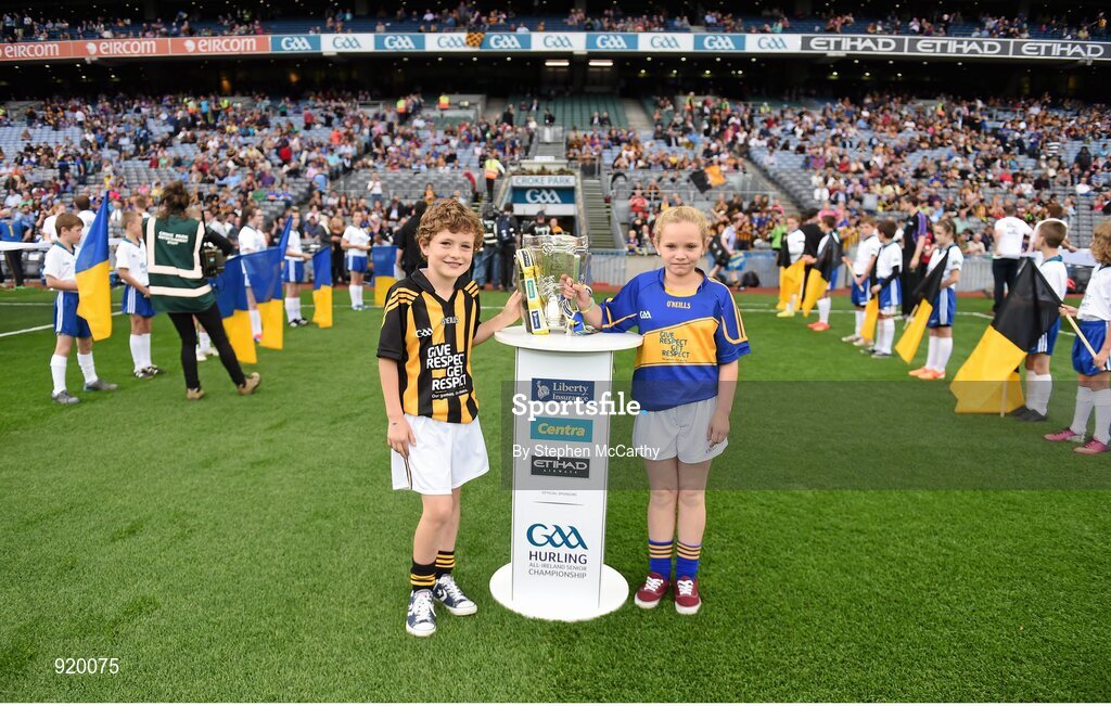 27 September 2014; Roísín O'Meara, Narnane NS, Tipperary, and Alex Cass, Thomastown NS, Kilkenny, carry the Liam MacCarthy cup onto the pitch ahead of the game. GAA Hurling All Ireland Senior Championship Final Replay, Kilkenny v Tipperary. Croke Park, Dublin. Picture credit: Stephen McCarthy / SPORTSFILE