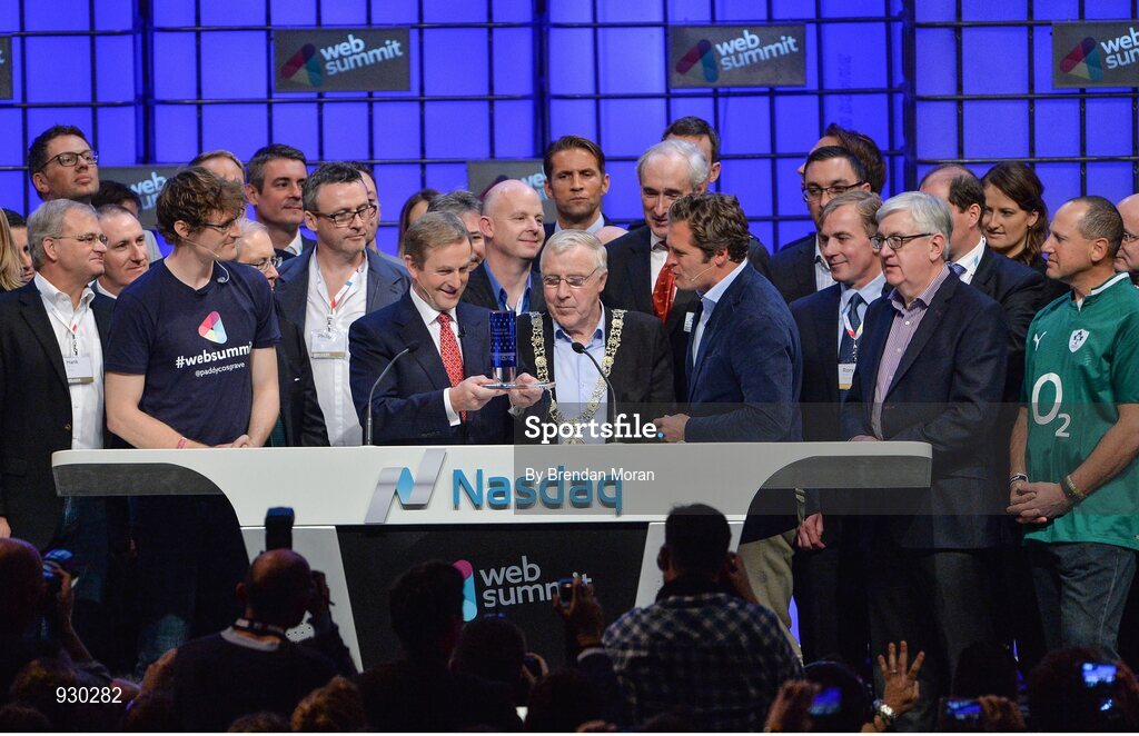 4 November 2014; An Taoiseach Enda Kenny, centre, receives a presentation from Adam KostyÃ¡l, Head of European Listings, NASDAQ OMX, after ringing the NASDAQ bell watched by Paddy Cosgrave, Founder and CEO, Web Summit, left and Cllr Christy Burke, Lord Major of Dublin, centre, on the centre stage during Day 1 of the 2014 Web Summit in the RDS, Dublin, Ireland. Picture credit: Brendan Moran / SPORTSFILE / Web Summit