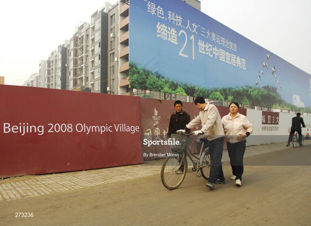 12 November 2007; Locals walk past the Olympic Village during preparations in Beijing ahead of the 2008 Summer Olympic Games. The 2008 Summer Olympics, officially known as the Games of the XXIX Olympiad, will be take place from the 8th August 2008 to 24th August 2008, at the Beijing National Stadium in Beijing, China. Beijing, China. Picture credit: Brendan Moran / SPORTSFILE