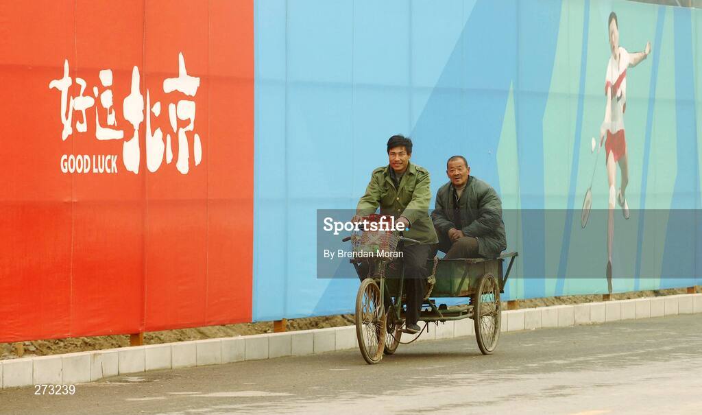 12 November 2007; Locals pass by perimeter fencing near the Beijing University of Technology Gymnasium during preparations in Beijing ahead of the 2008 Summer Olympic Games. The 2008 Summer Olympics, officially known as the Games of the XXIX Olympiad, will be take place from the 8th August 2008 to 24th August 2008, at the Beijing National Stadium in Beijing, China. Beijing, China. Picture credit: Brendan Moran / SPORTSFILE