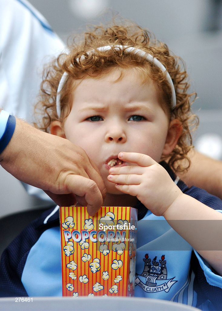 15 July 2007; Young Dublin supporter Molly Tresson, age 3, eats some popcorn as her father Sean, originally from Dublin but living in Wexford, takes some for himself, before the game. Bank of Ireland Leinster Senior Football Championship Final, Dublin v Laois, Croke Park, Dublin. Picture by; Brendan Moran / SPORTSFILE