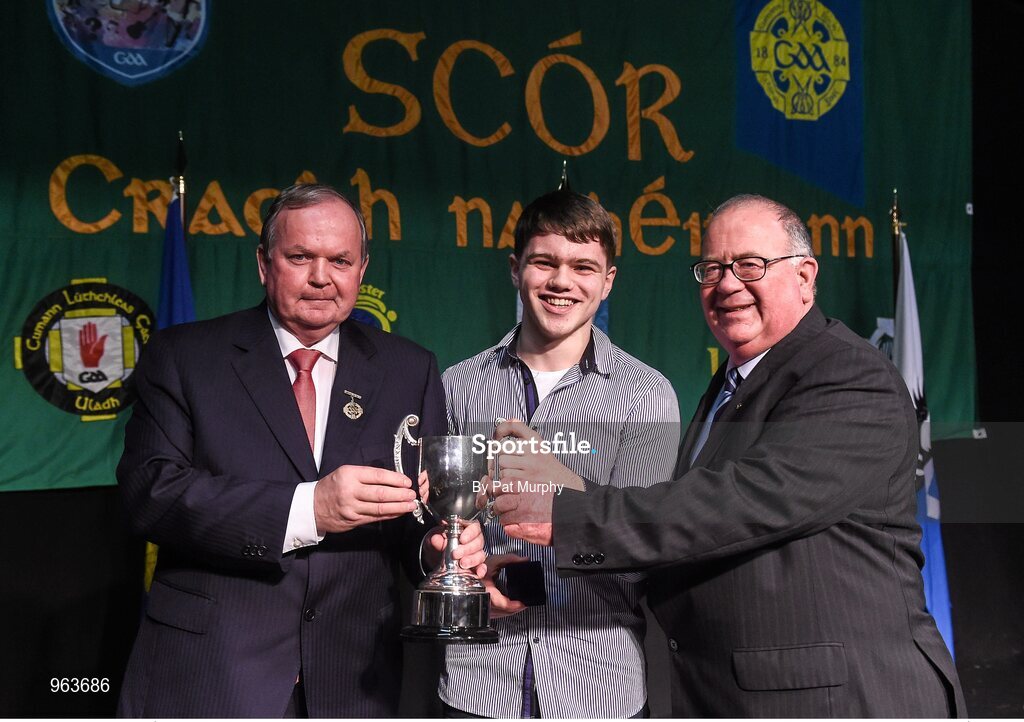 14 February 2015; Proinsias Ó Cathasaigh, Lios Póil, Co. Kerry, is presented with his trophy by Uachtaran Cumann Luthcleas Gael Liam O Neill, left, and Liam O Laochdha, Cathaoirleach, Coiste Naisiunta Scor, right, after winning the Solo Singing competition during the All-Ireland Scór na nÓg Championship Finals 2015. Citywest Hotel, Saggart, Co. Dublin. Picture credit: Pat Murphy / SPORTSFILE