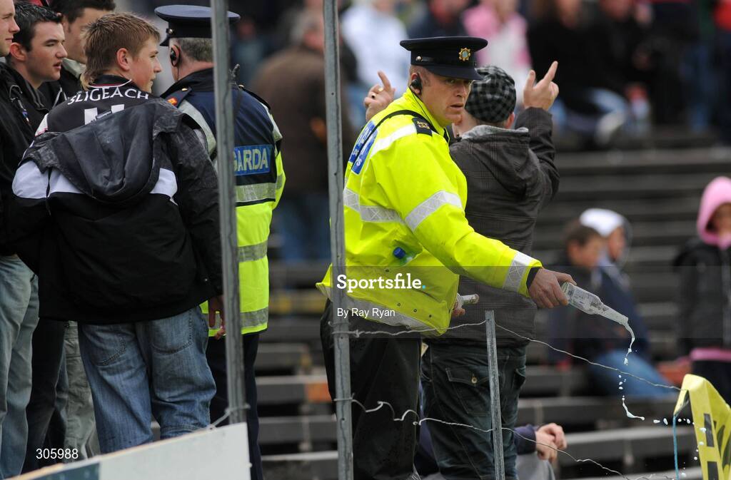 22 June 2008; A Garda empties a bottle of alcohol after confiscating it from supporters in the crowd. GAA Football Connacht Senior Championship Semi-Final, Mayo v Sligo, McHale Park, Castlebar, Co. Mayo. Picture credit: Ray Ryan / SPORTSFILE