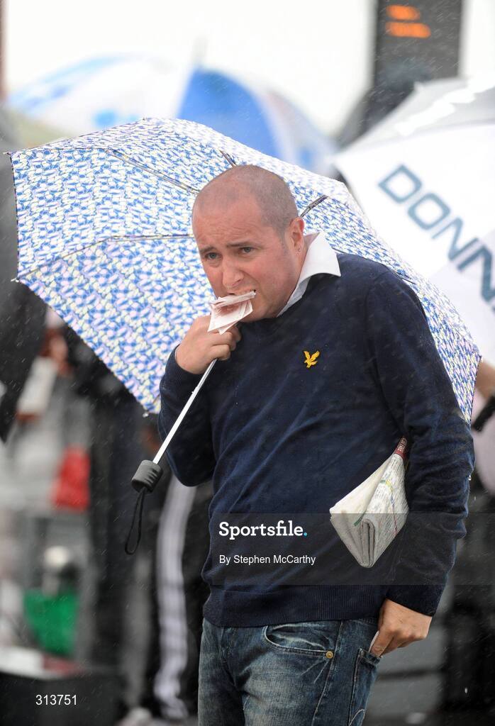 29 July 2008; A punter struggles with the elements during the second day of the Galway Racing Festival. Galway Racing Festival - Tuesday, Ballybrit, Galway. Picture credit: Stephen McCarthy / SPORTSFILE