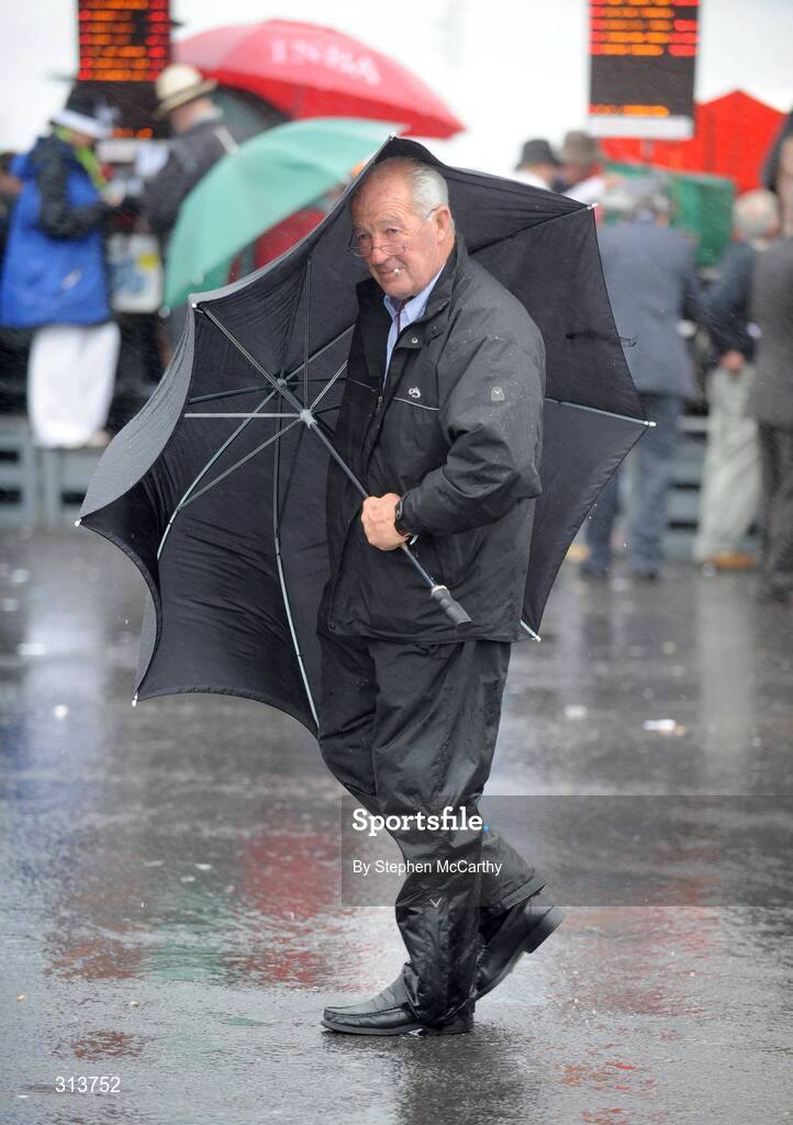 29 July 2008; A punter struggles with the elements during the second day of the Galway Racing Festival. Galway Racing Festival - Tuesday, Ballybrit, Galway. Picture credit: Stephen McCarthy / SPORTSFILE