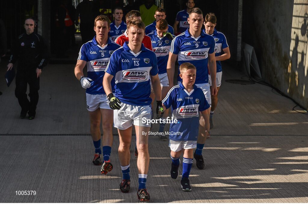6 June 2015; Laois captain Ross Munnelly accompanied by mascot Callum McElroy, from the Arles Kilcruise GAA Club, lead the team out ahead of the game. Leinster GAA Football Senior Championship Quarter-Final, Kildare v Laois. O'Connor Park, Tullamore, Co. Offaly. Picture credit: Stephen McCarthy / SPORTSFILE