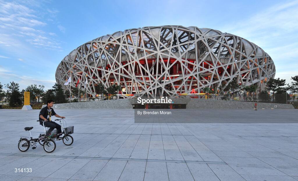 1 August 2008; A local resident cycles past the National Stadium with two bicycles as preparations continue ahead of the opening ceremony on Friday next, 8th of August. Beijing 2008 - Games of the XXIX Olympiad, National Stadium, Olympic Green, Beijing, China. Picture credit: Brendan Moran / SPORTSFILE