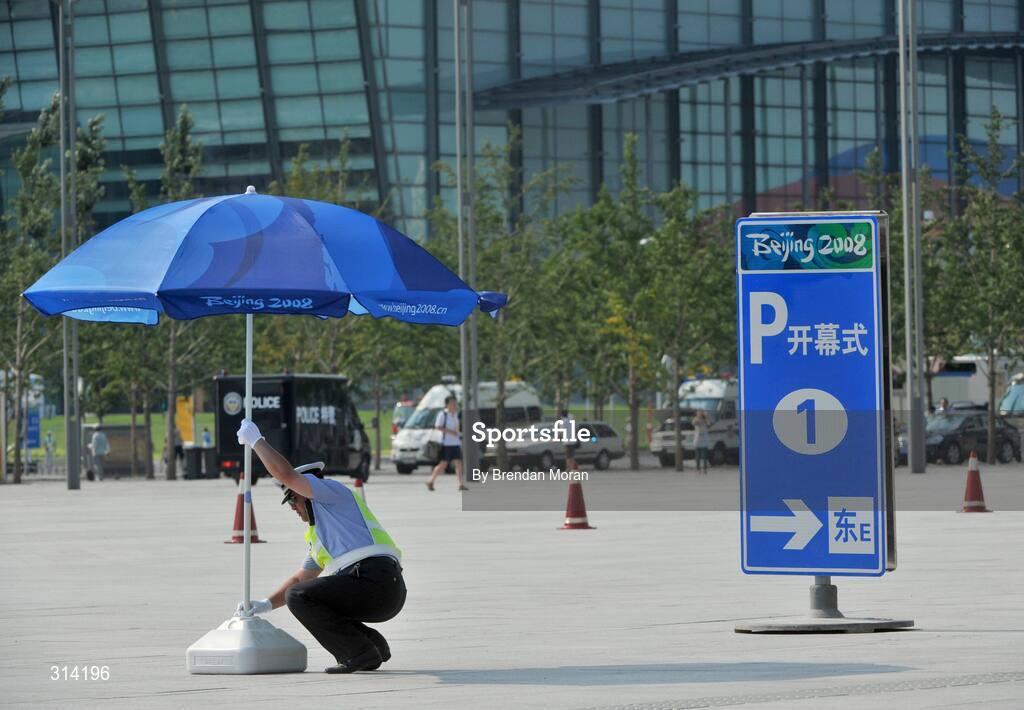 2 August 2008; A policeman adjusts his parasol while shading from the heat as preparations continue ahead of the opening ceremony on Friday next, 8th of August. Beijing 2008 - Games of the XXIX Olympiad, Olympic Green, Beijing, China. Picture credit: Brendan Moran / SPORTSFILE