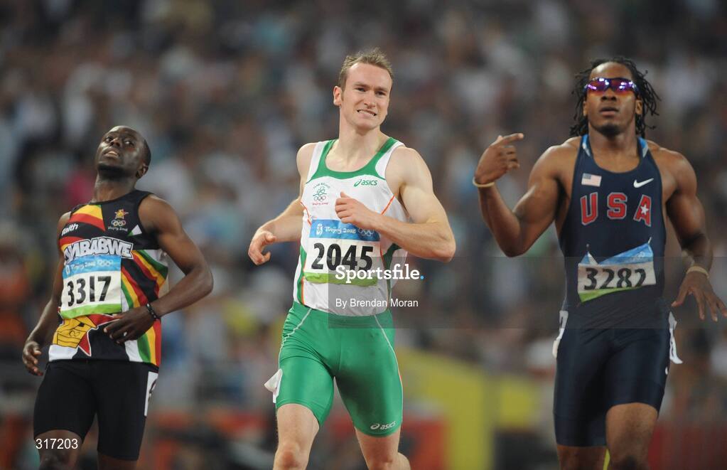 19 August 2008; Paul Hession, Ireland, alongside Brian Dzingai, left, of Zimbabwe, and Walter Dix, of the USA, reacts after crossing the line in semi-final of the Men's 200m, in which he finished 4th in a time of 20.38 seconds and 10th overall. The first 8 made the final. Beijing 2008 - Games of the XXIX Olympiad, National Stadium, Olympic Green, Beijing, China. Picture credit: Brendan Moran / SPORTSFILE