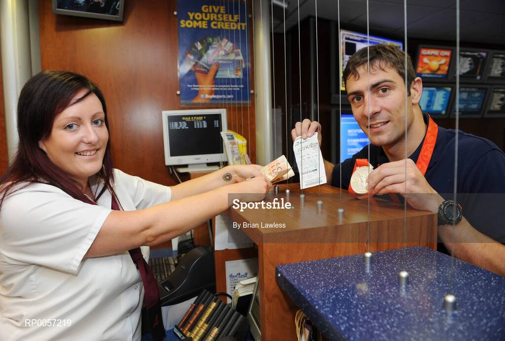 29 August 2008; Olympic boxing silver medalist Kenny Egan collects his winnings from Helen Gordon at the Boylesports shop in Neilstown. Kenny collected his winnings after he placed a bet on himself to win a medal in Beijing. Boylesports generously trebled his winnings and gave the same amount to Kenny’s club in Neilstown to prepare the boxers of the future. Boylseports, Clondalkin, Dublin. Picture credit: Brian Lawless / SPORTSFILE