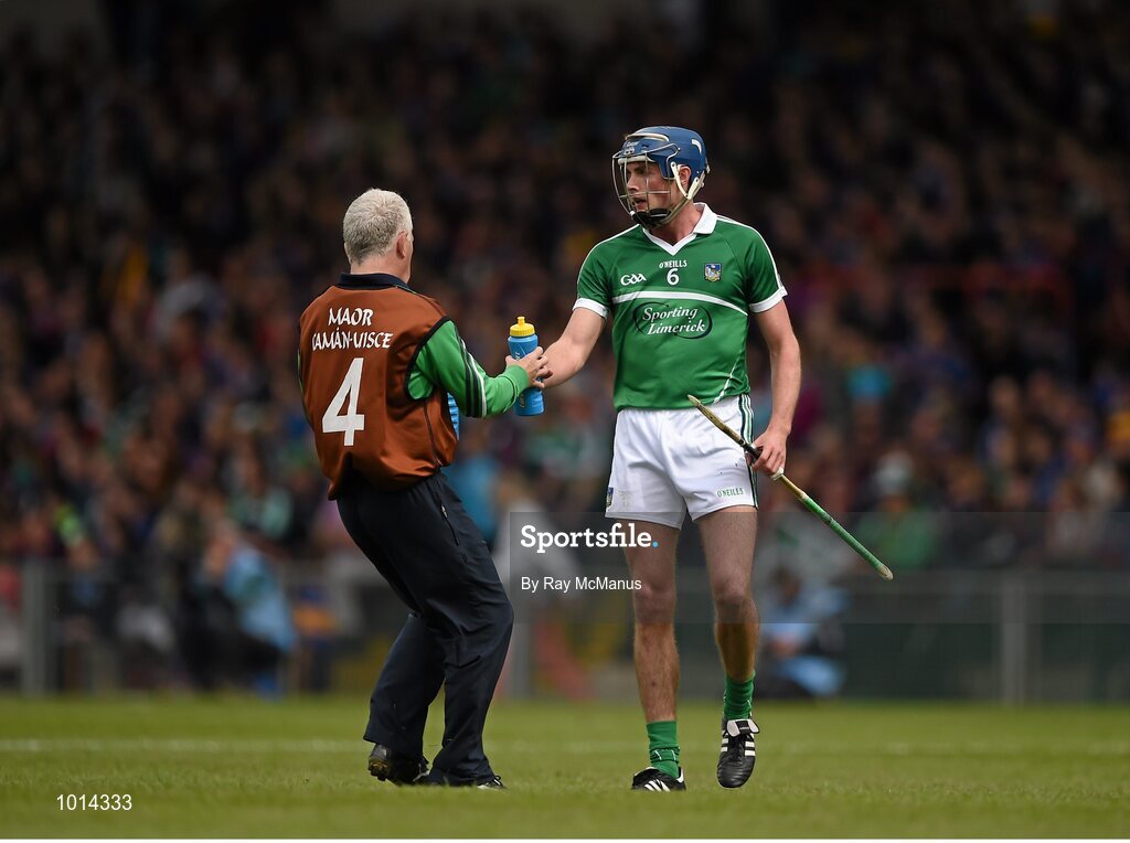 21 June 2015; Member of the Limerick backroom team Conor McCarthy gives water to Gavin O'Mahony during the game. Munster GAA Hurling Senior Championship, Semi-Final, Limerick v Tipperary, Gaelic Grounds, Limerick. Picture credit: Ray McManus / SPORTSFILE