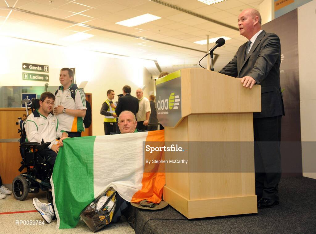 19 September 2008; Minister of State at the Department of the Taoiseach and Government Chief Whip Pat Carey speaking at a reception for Irish athletes at Dublin Airport as the Irish Paralympic Team arrived home from Beijing while Sports Assistant Patrick 'Rocky' Judge holds an Irish flag. Dublin Airport, Dublin. Picture credit: Stephen McCarthy / SPORTSFILE