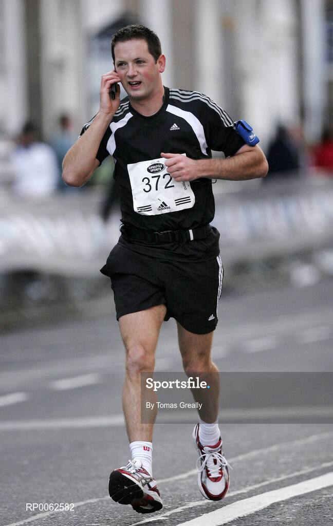27 October 2008; Jonathan Ruane, from Kildare, takes a call on his mobile phone during the Lifestyle Sports - adidas Dublin Marathon 2008. Merrion Square, Dublin. Picture credit: Tomas Greally / SPORTSFILE