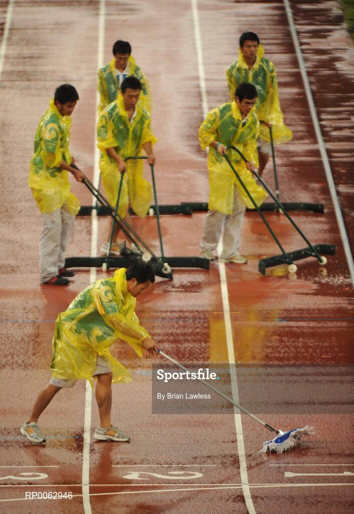 16 September 2008; Volunteers dry the track after a heavy downpour. Beijing Paralympic Games 2008, National Stadium, Olympic Green, Beijing, China. Picture credit: Brian Lawless / SPORTSFILE