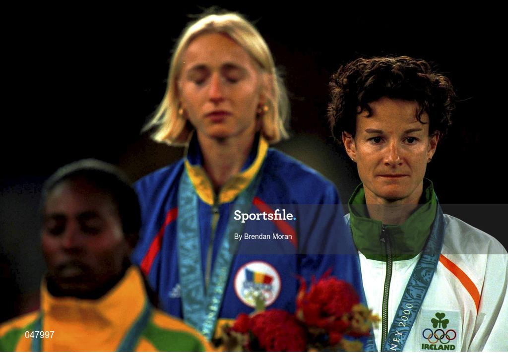 25 September 2000;  Ireland's Sonia O'Sullivan looks on after receiving her silver medal in the Women's 5000m as Gold Medallist Gabriela Szabo, centre, Romania and Bronze Medallist Gete Wami, Ethiopia, listen to the Romanian National Anthem. Stadium Australia, Sydney Olympic Park. Homebush Bay, Sydney, Australia. Photo by Brendan Moran/Sportsfile