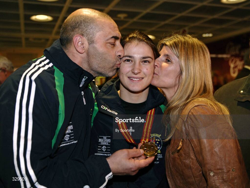1 December 2008; Ireland's Katie Taylor, who won a gold medal in the 60kg category at the AIBA Women's World Championships in China, gets a kiss from her Dad and trainer Peter and mother Bridget at the homecoming in Dublin Airport. Photo by Sportsfile