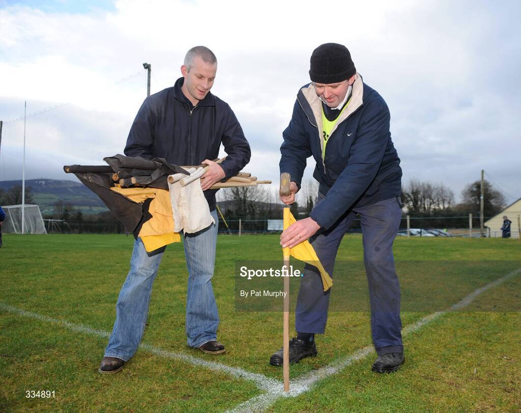 25 January 2009; Groundsmen Joseph Mooney, left, and Pat Gavin prepare the flags around the pitch before the game. Waterford Crystal Cup Hurling Final, Clare v Tipperary, Ogonnolloe, Co. Clare. Picture credit: Pat Murphy / SPORTSFILE