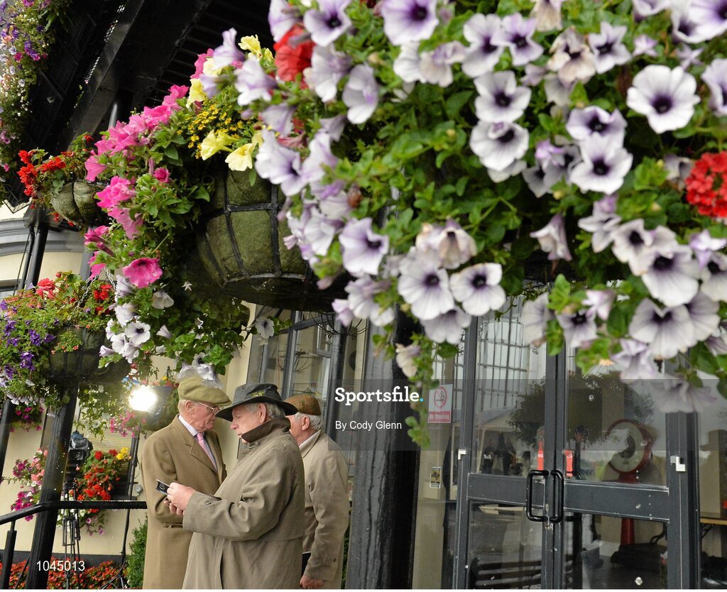 23 August 2015; Punters study their race cards under a balcony. Horse Racing from the Curragh. Curragh, Co. Kildare. Picture credit: Cody Glenn / SPORTSFILE