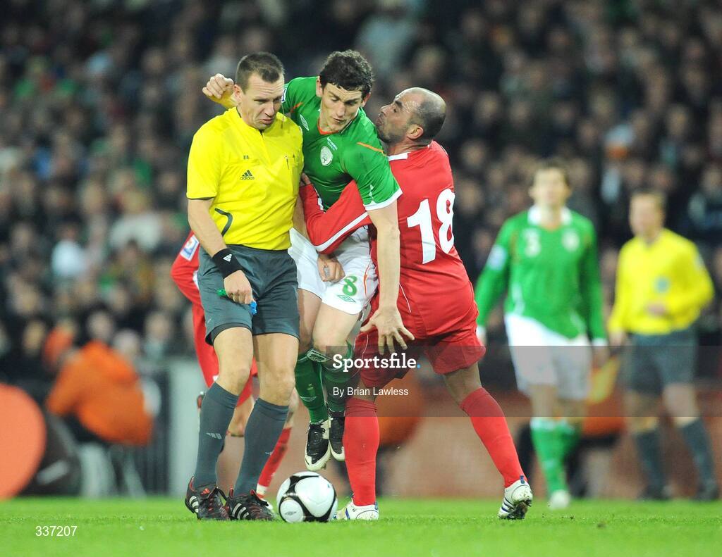 11 February 2009; Keith Andrews, Republic of Ireland, has his path blocked by Zurab Menteshashvili, Georgia, and referee Jouni Hyytia. 2010 FIFA World Cup Qualifier, Republic of Ireland v Georgia, Croke Park, Dublin. Picture credit: Brian Lawless / SPORTSFILE