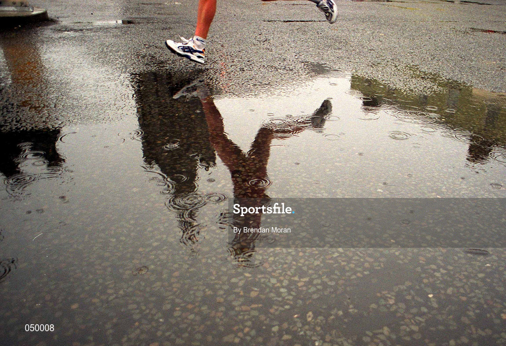30 October 2000; A runner is reflected in a puddle during the rain soaked 2000 98FM Dublin City Marathon in Dublin. Photo by Brendan Moran/Sportsfile