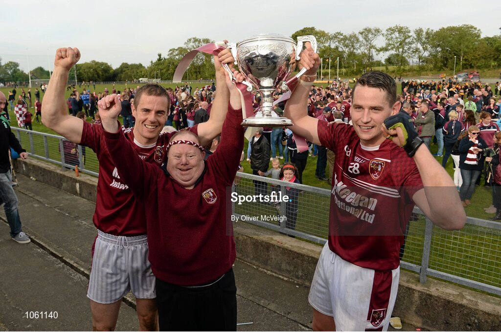 27 September 2015; Ruairi Og Cushendall joint captains Sean Delargy and Aaron Graffin, along with team mascot John McKillop, celebrate with the Volunteer cup. Antrim Senior Championship Hurling Final, Ruairi Og Cushendall v Ballycastle McQuillan, Dunloy GAA Club, Dunloy, Co. Antrim. Picture credit: Oliver McVeigh / SPORTSFILE