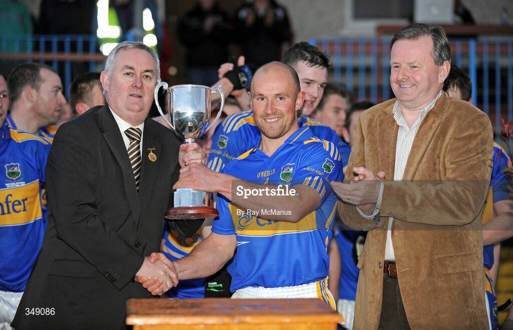25 April 2009; The Tipperary captain Andrew Morrissey is presented with the trophy by GAA President Christy Cooney in the company of Damien O'Neill, Marketing Director Allianz, representing the sponsors after the Allianz GAA National Football League, Division 3 Final match between Down and Tipperary at Pearse Park in Longford. Photo by Ray McManus/Sportsfile