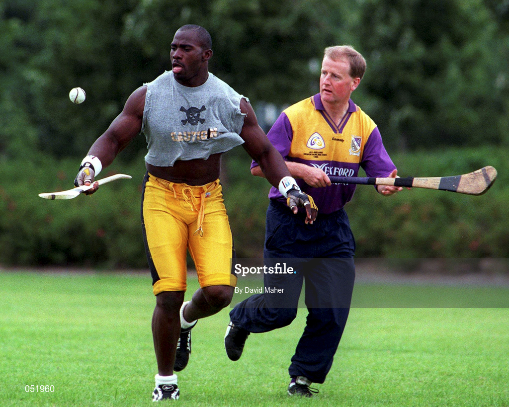 23 July 1997; Chicago Bears line backer Greg Lloyd demonstrates his hurling skills to Wexford Hurler Tom Dempsey at a photo call at UCD in Belfield, Dublin, ahead of the Budweiser American Bowl. Photo by David Maher/Sportsfile