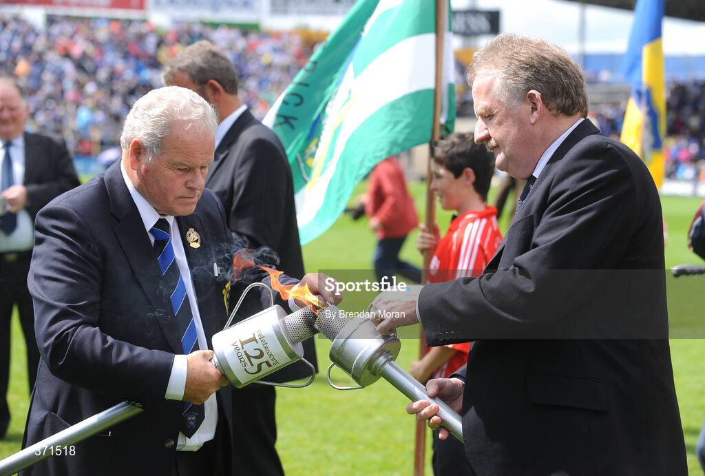 12 July 2009; Michael O'Neill, right, Chairman of the Clare County Board, has his torch lit by Jimmy O'Gorman, Chairman of the Munster Council, during the pre-match celebrations. GAA Hurling Munster Senior Championship Final, Tipperary v Waterford, Semple Stadium, Thurles, Co. Tipperary. Picture credit: Brendan Moran / SPORTSFILE