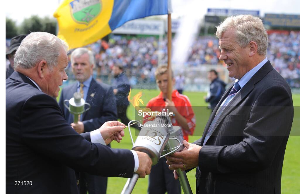12 July 2009; Jerry O'Sullivan, right, Chairman of the Cork County Board, has his torch lit by Jimmy O'Gorman, Chairman of the Munster Council, during the pre-match celebrations. GAA Hurling Munster Senior Championship Final, Tipperary v Waterford, Semple Stadium, Thurles, Co. Tipperary. Picture credit: Brendan Moran / SPORTSFILE