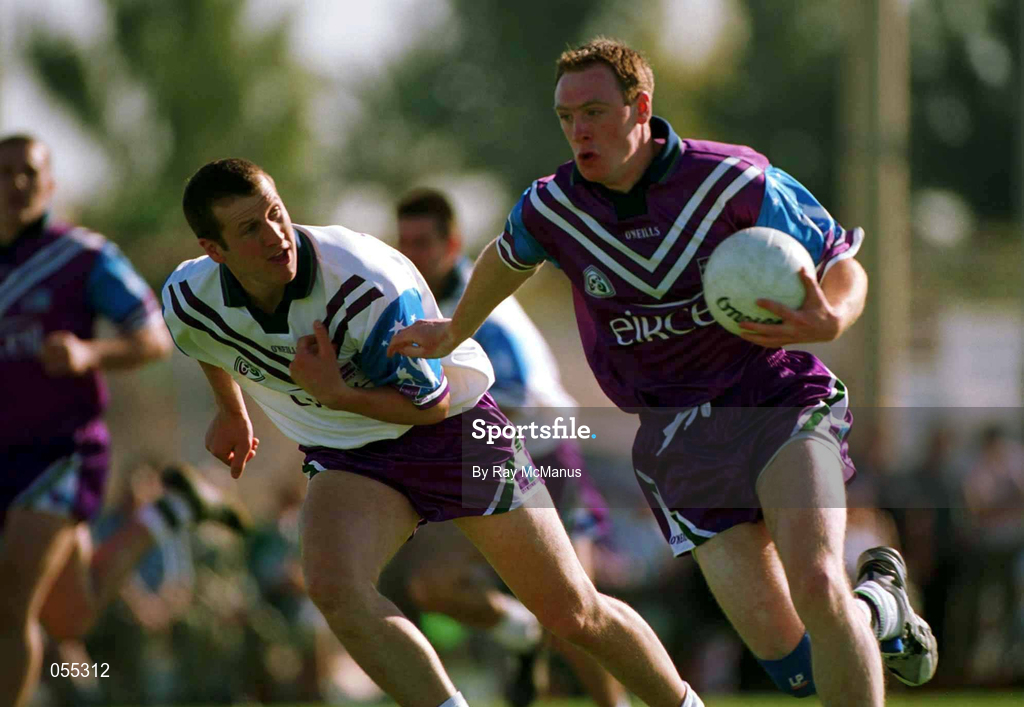 26 January 2001; Philip Clifford of 1999 All Stars, races past Gary Fahey of 2000 All Stars during an exhibition match on the Eircell GAA All-Star tour at the Dubai Rugby Ground in Dubai, United Arab Emirates. Photo by Ray McManus/Sportsfile