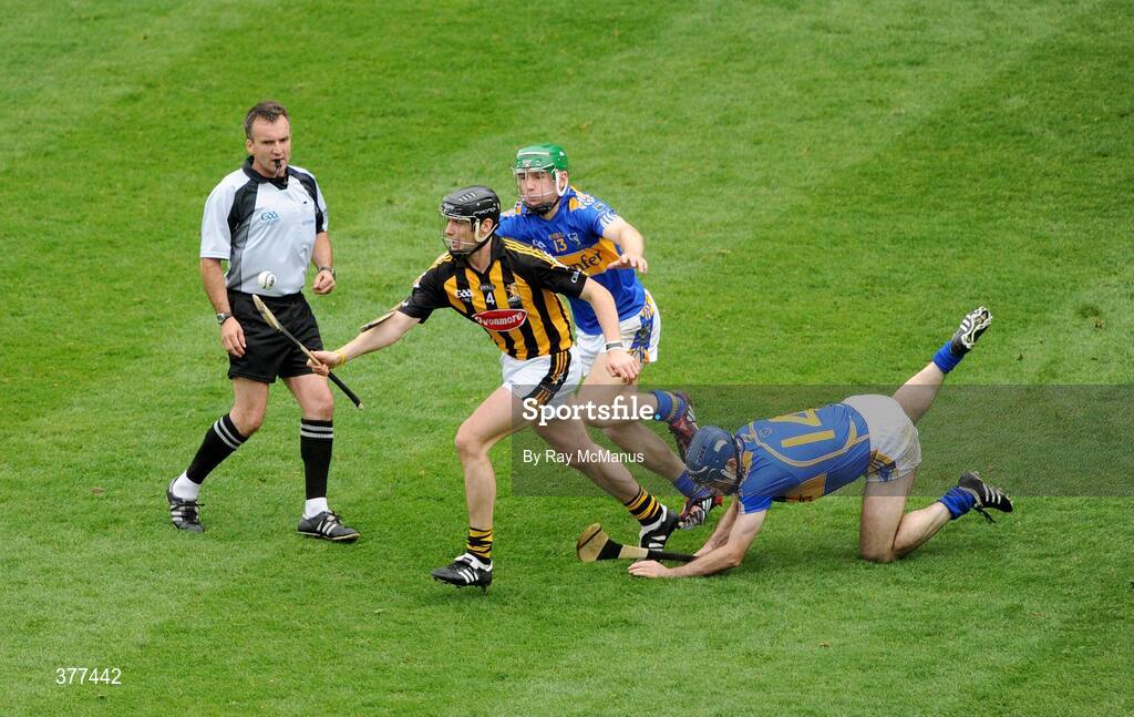 6 September 2009; Jackie Tyrrell, Kilkenny, slips past referee Diarmuid Kirwan as he prepares to clear from Tipperary forwards Noel McGrath and Eoin Kelly . GAA Hurling All-Ireland Senior Championship Final, Kilkenny v Tipperary, Croke Park, Dublin. Picture credit: Ray McManus / SPORTSFILE
