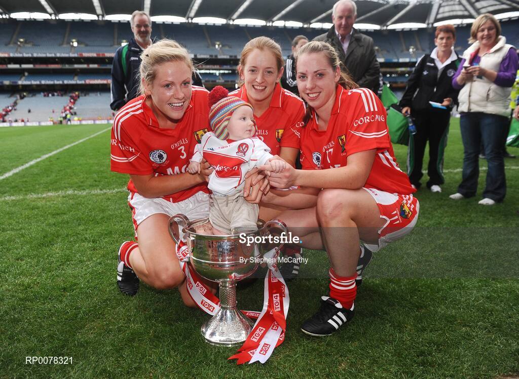 27 September 2009; Cork players, from left, Angela Walsh, Juliet Murphy and Linda Barrett celebrate with Fiachra McGill, age 6 months, grandson of manager Eamon Ryan, and the Brendan Martin cup. TG4 All-Ireland Ladies Football Senior Championship Final, Cork v Dublin, Croke Park, Dublin. Picture credit: Stephen McCarthy / SPORTSFILE