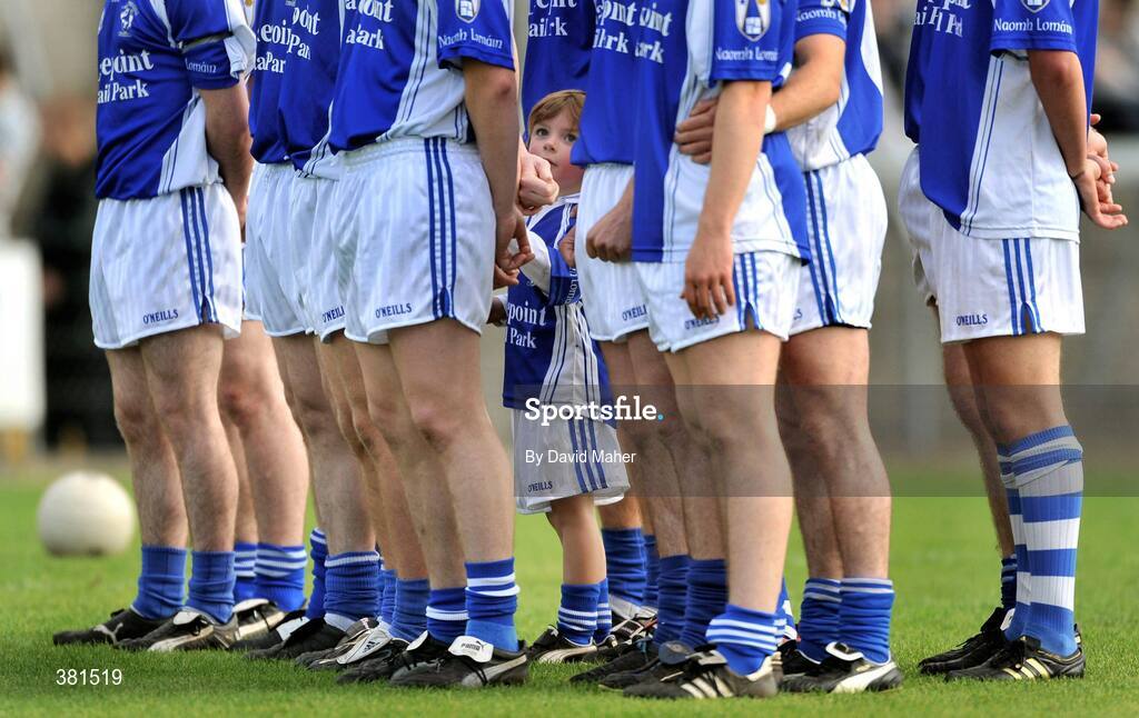 4 October 2009; Mascot Killian Plunkett stands with the players of St Loman's, Mullingar, during the playing of the national anthem. Westmeath County Senior Football Final, St Loman's, Mullingar v Garrycastle, Cusack Park, Mullingar, Co. Westmeath. Picture credit: David Maher / SPORTSFILE