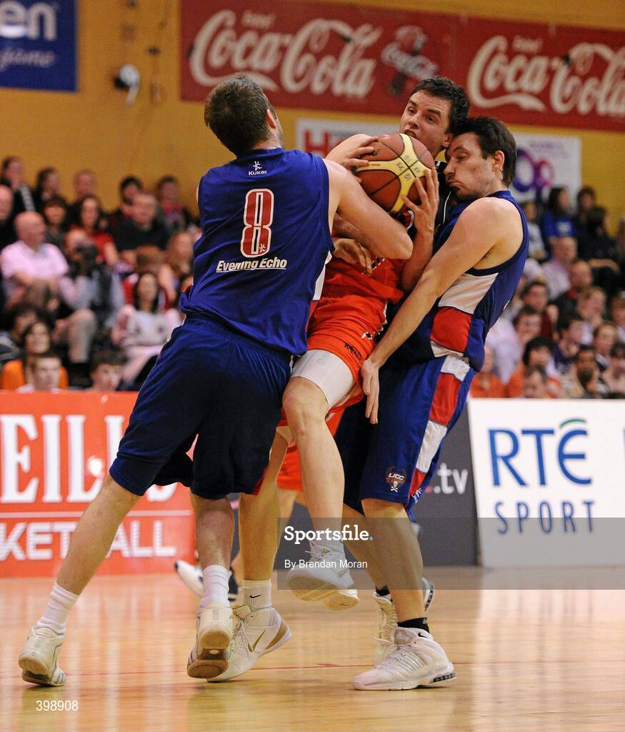 31 January 2010; Paddy Kelly, Killester, is fouled by Shane Coughlan, 8, and David Murphy, UCC Demons. Men's Superleague National Cup Final 2010, Killester v UCC Demons, National Basketball Arena, Tallaght, Dublin. Picture credit: Brendan Moran / SPORTSFILE