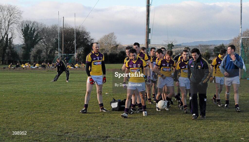 31 January 2010; Wexford football manager Jason Ryan leads his team out, while in the background, the Wexford hurling team do their warm down. O'Byrne Shield Semi-Final, Pairc Ui Siochan, Wexford v Westmeath, Gorey, Co. Wexford. Picture credit: Daire Brennan / SPORTSFILE