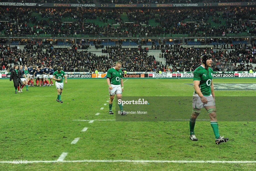 13 February 2010; Dejected Irish players, from right, Stephen Ferris, Tom Court and Gordon D'Arcy leave the pitch as the French team celebrate their victory. RBS Six Nations Rugby Championship, France v Ireland, Stade de France, Saint Denis, Paris, France. Picture credit: Brendan Moran / SPORTSFILE