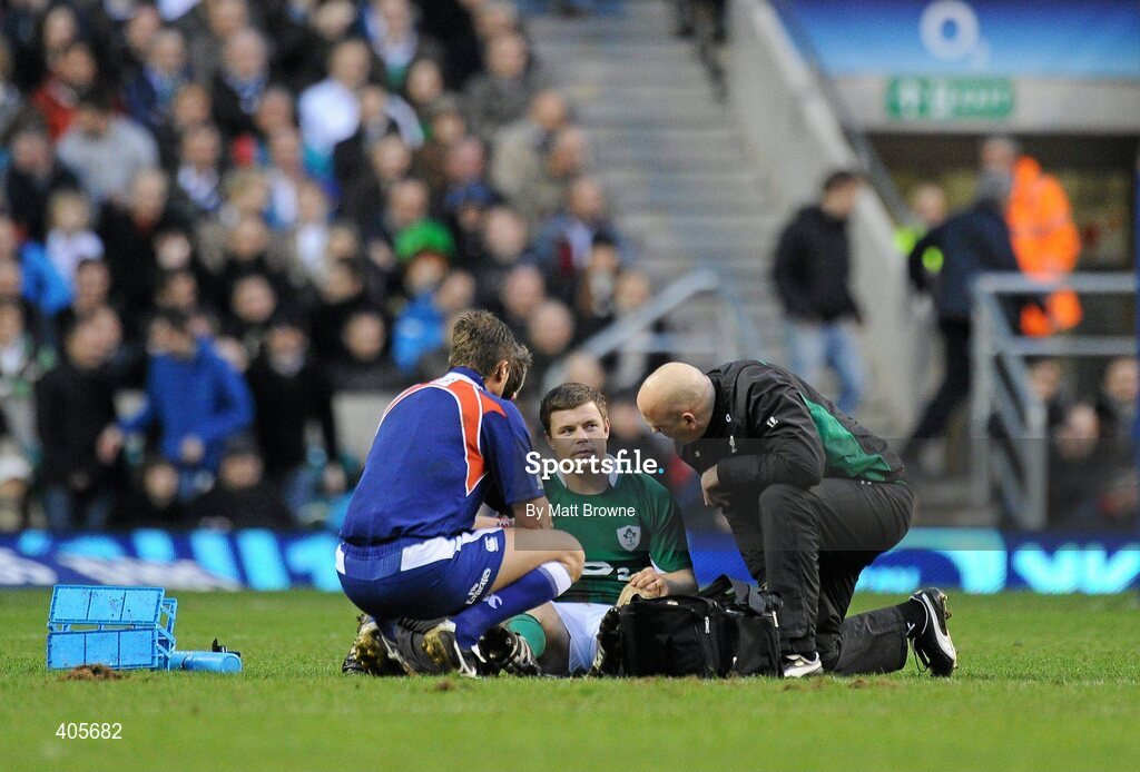 27 February 2010; Brian O'Driscoll, Ireland, receives attention from physio Cameron Steele, hidden, and team doctor Eanna Falvey, right, as referee Mark Lawrence looks on. RBS Six Nations Rugby Championship, England v Ireland, Twickenham Stadium, Twickenham, London, England. Picture credit: Matt Browne / SPORTSFILE